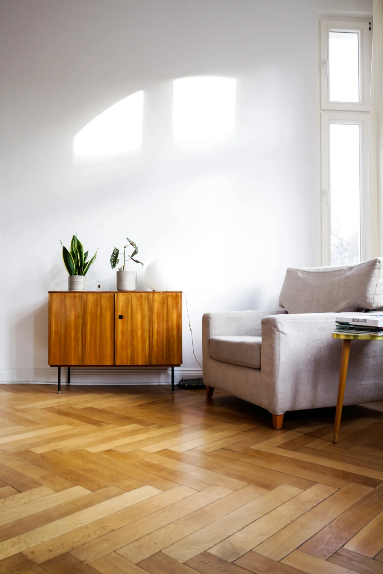 Sunlit room with a herringbone wood floor and an armchair